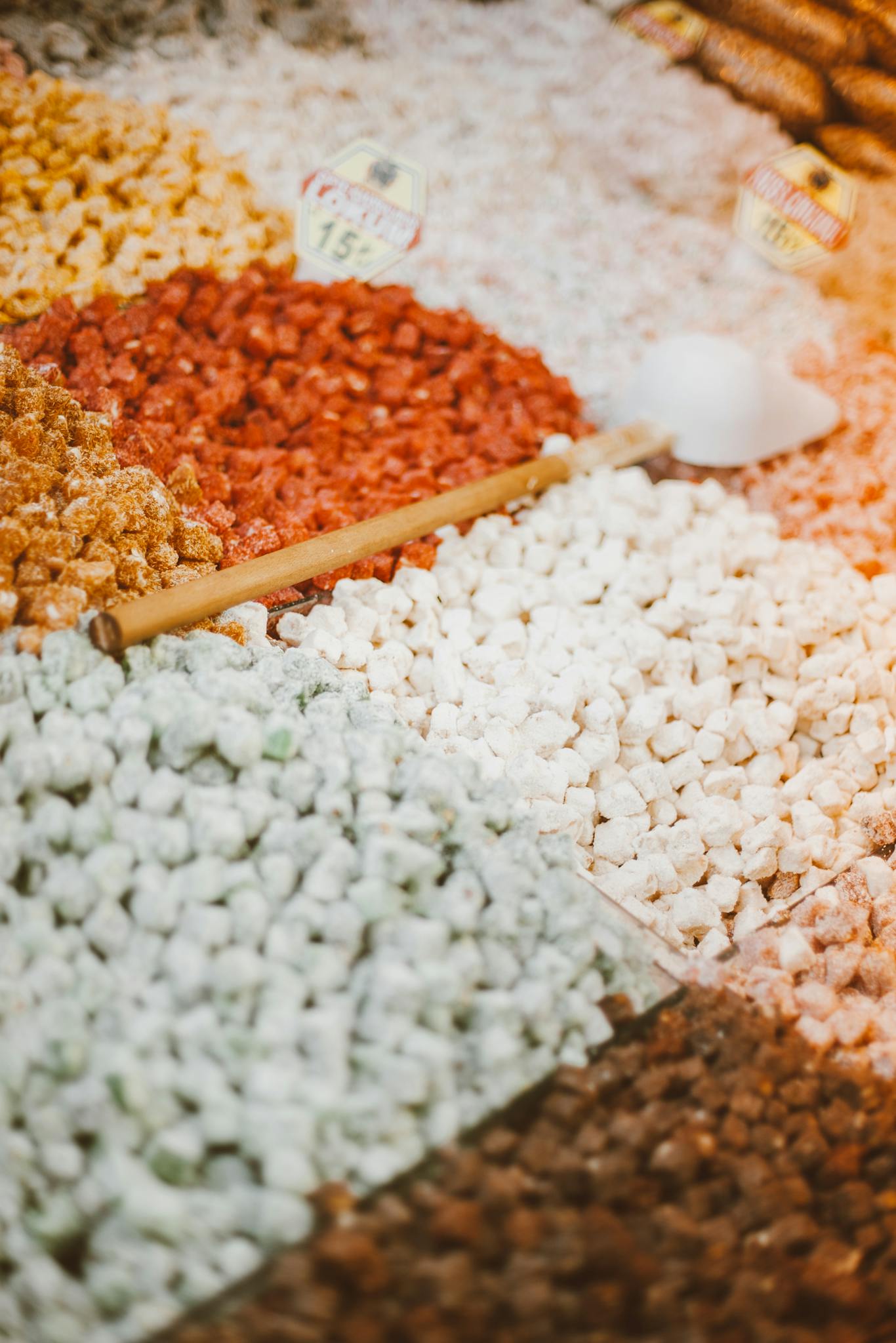 Colorful assortment of spices in a market with a focus on texture and variety.